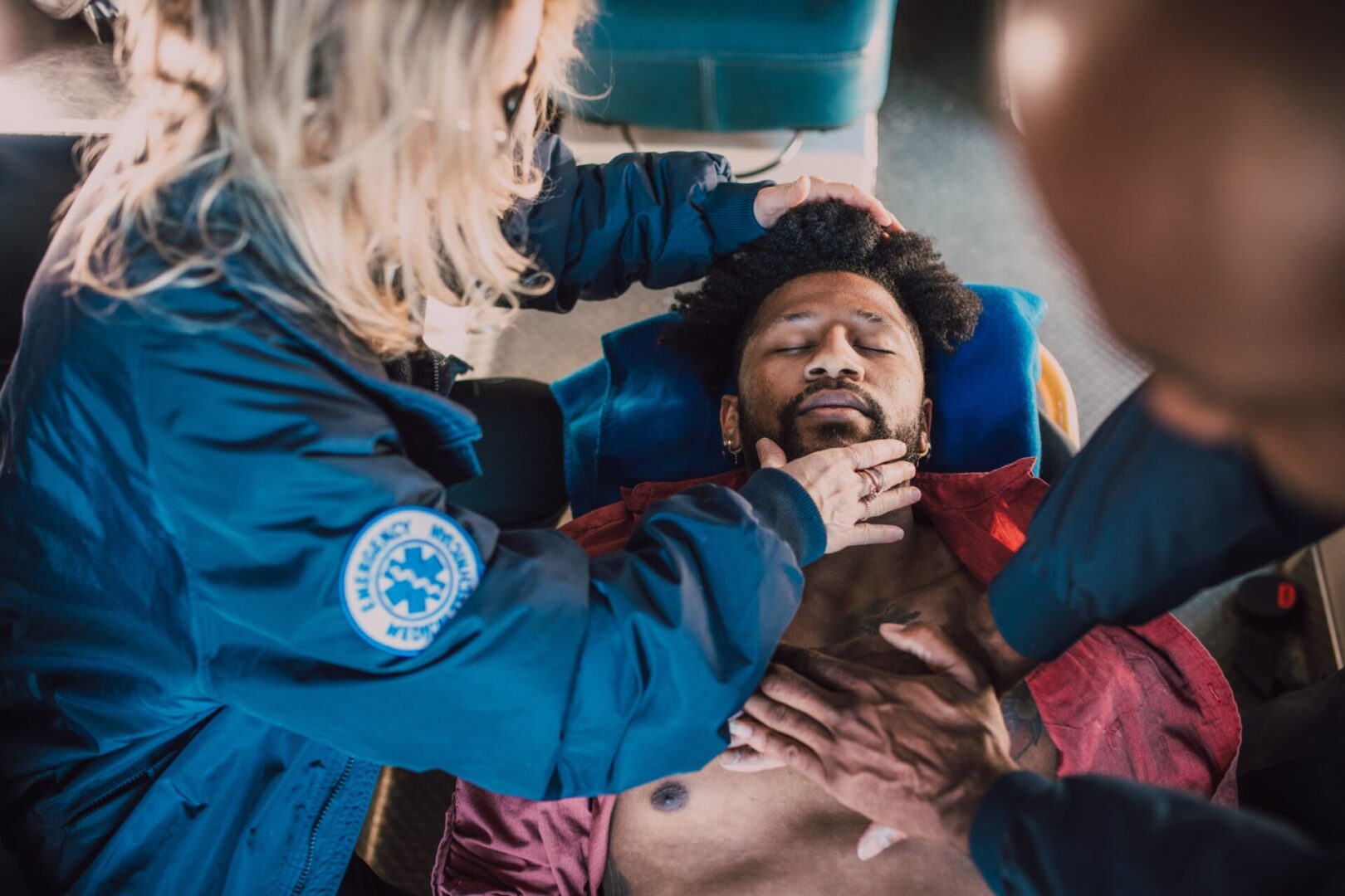 A person is getting his face examined by an emergency medical worker.